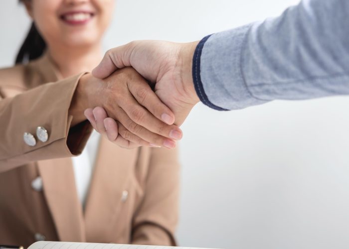 Two businesspeople shaking hands during a meeting to sign agreement and become a business partner, enterprises, companies, confident, success dealing, contract between their firms.